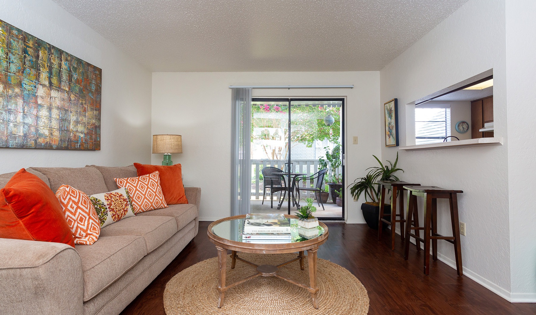 Living Room  Spacious and well lit living room with wood floors and an open floor plan with access to the kitchen.